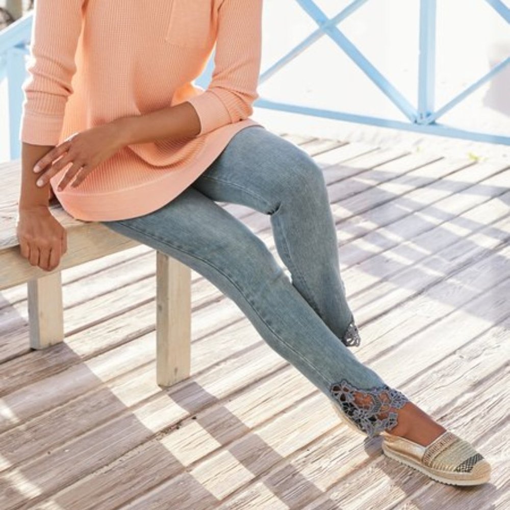 Light wash jeans with lace insets at the hems
